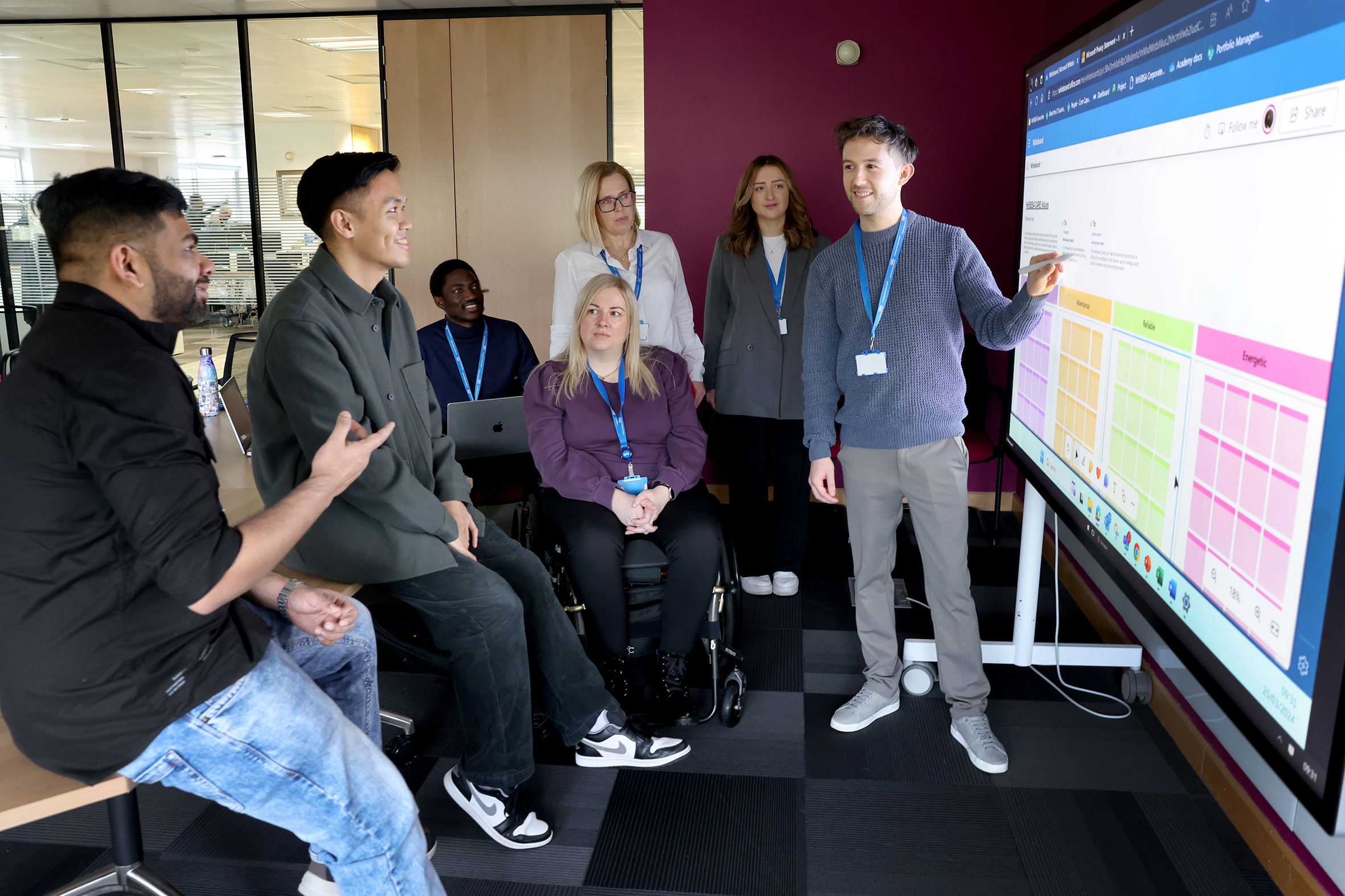 A group discussing the content of a large display screen