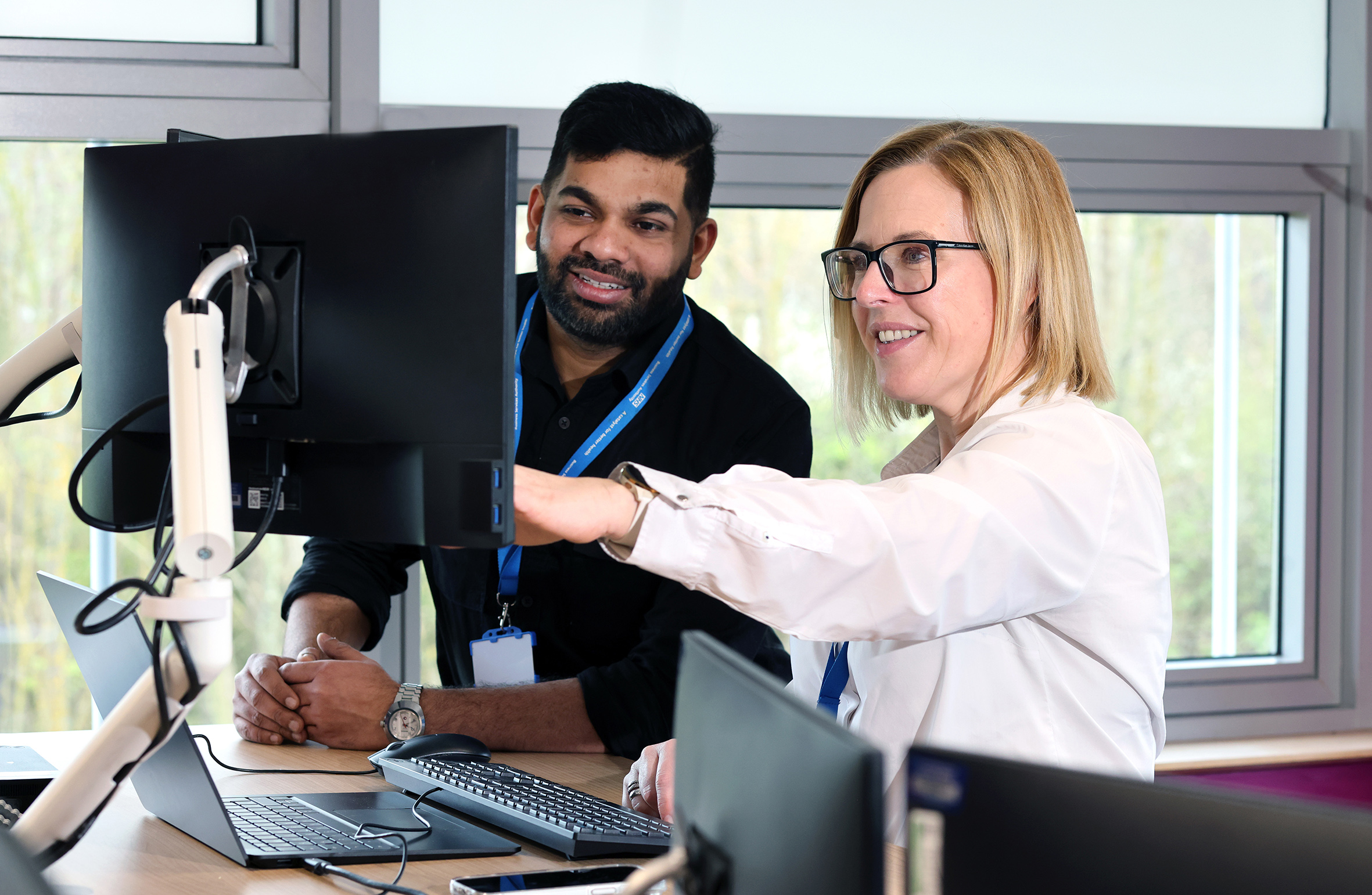 Smiling people looking at a computer monitor