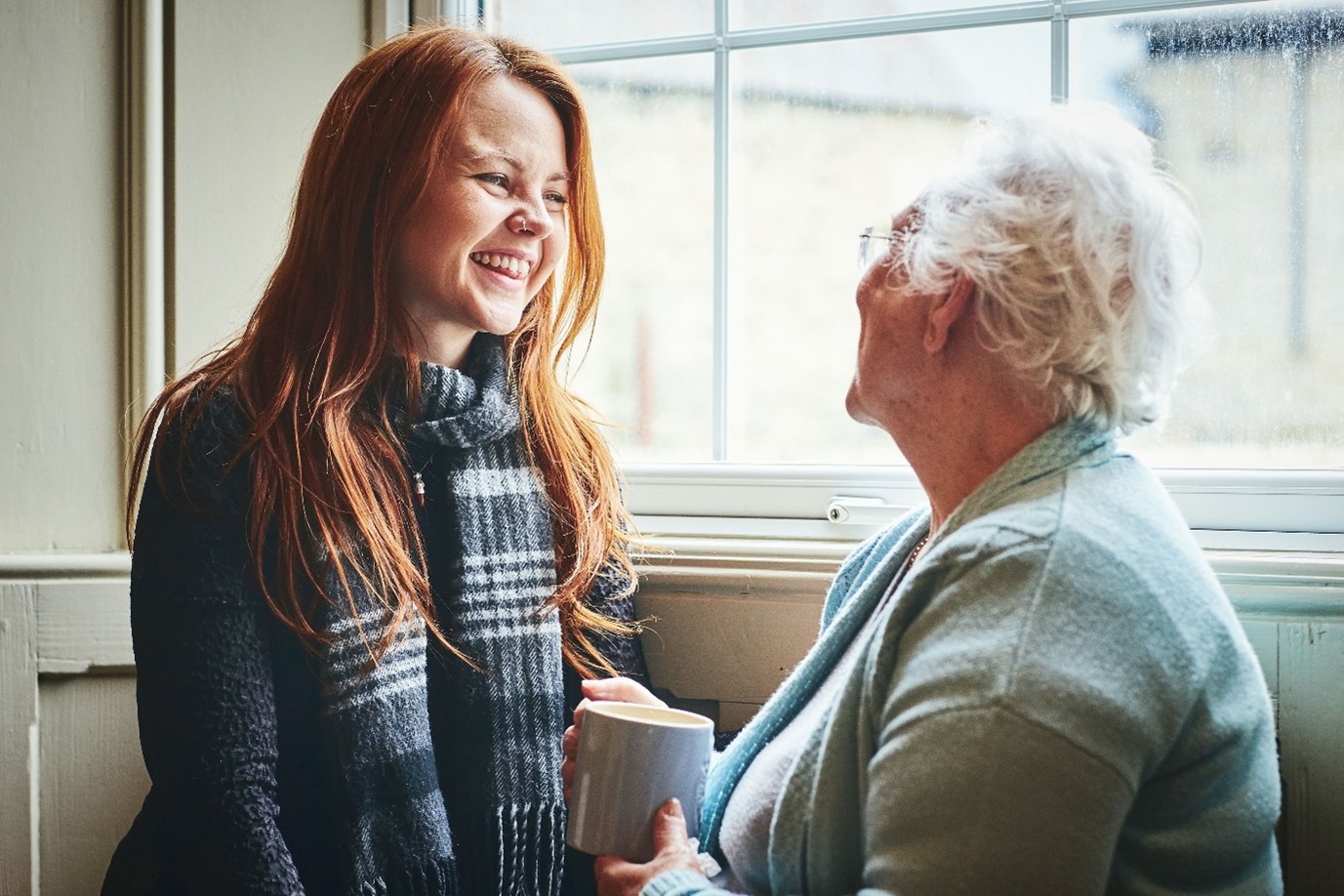 Volunteer laughing and chatting with older lady